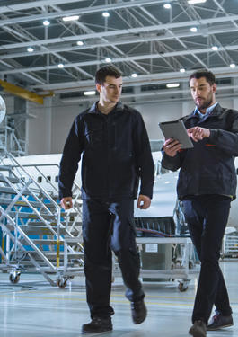 2 men in an  warehouse with planes